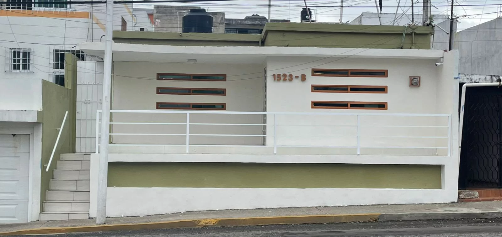 Fachada de la clínica con el número 1523-B y escaleras de acceso