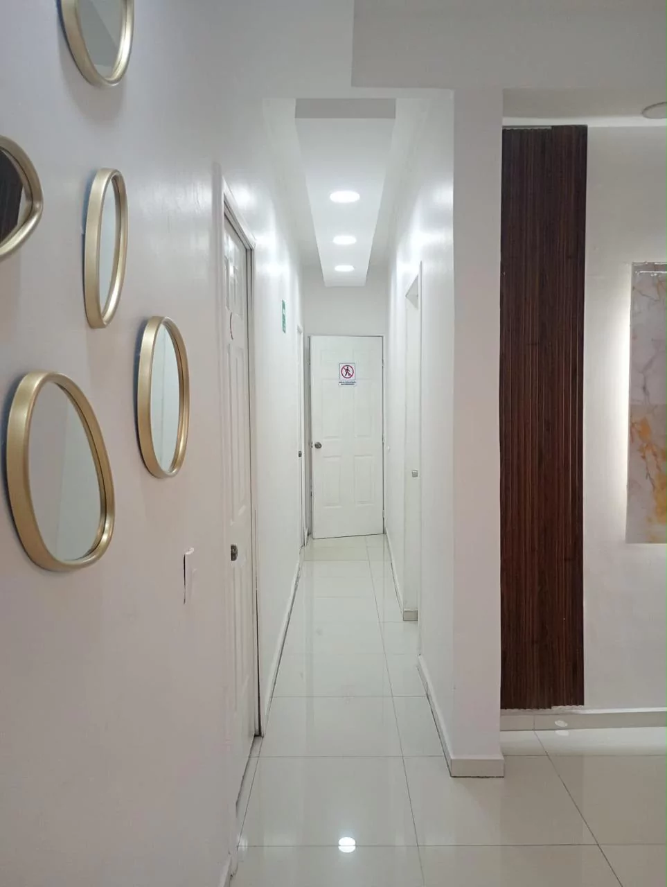 Pasillo de consultorios de Dentia con espejos dorados